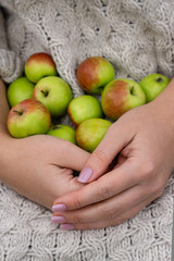 Woman holds green apples with her hands