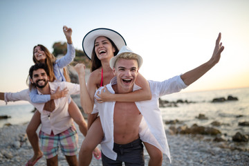 Group of friends having fun on the beach on vacation