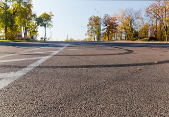 Tire tracks on asphalt ground with road marking close-up
