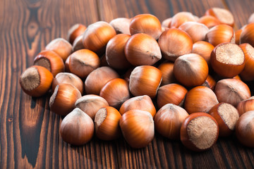 close up of hazelnuts on wooden table .