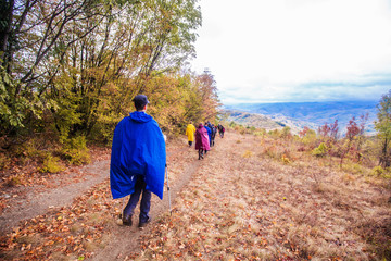Rearview of unrecognizable people hiking on a rainy day in nature