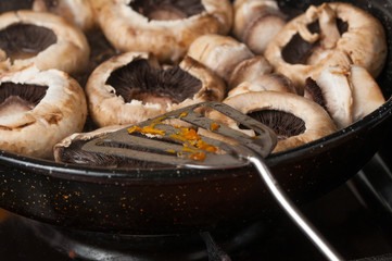 Roasting mushrooms in a black frying pan.Healthy food