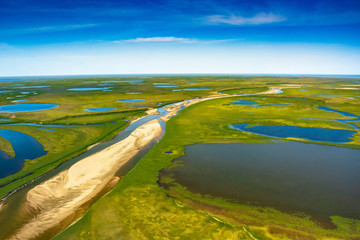 Landscape of the arctic tundra in summer. Rivers, lakes, northern vegetation. View from above. The...