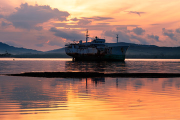 Old boat in the sea beautiful sunrise at phuket thailand