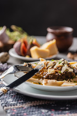 Fresh and simple homemade food. Plate of delicious pasta with mushroom sauce and parmesan on a rustic napkin. Close-up.
