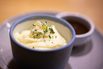 Mashed potatoes in bowl with pepper-cream gravy sauce.