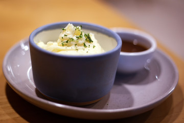 Mashed potatoes in bowl with pepper-cream gravy sauce.