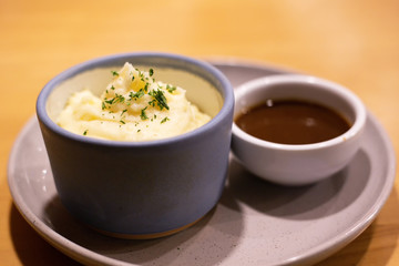 Mashed potatoes in bowl with pepper-cream gravy sauce.