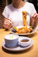 Hand woman holding fork for eating spaghetti meatball at dining time.