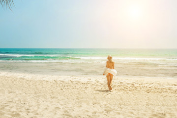 Fototapeta na wymiar Happy traveller woman in white enjoys her tropical beach vacatio