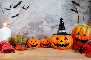 Accessories of decorations Happy Halloween day background concept.Jack O lantern pumpkin objects and light candle to party season with spider on brown & stone backdrop at home office desk studio.