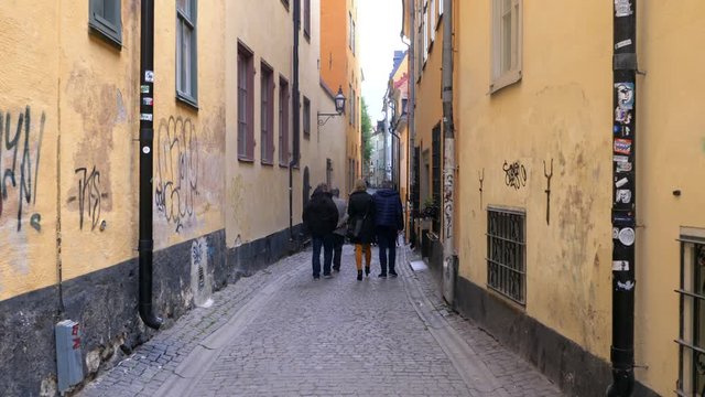 People walking in narrow alley in Old Town, Stockholm, Sweden.