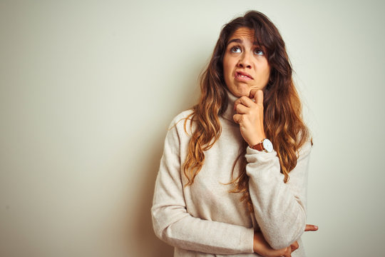 Young beautiful woman wearing winter sweater standing over white isolated background Thinking worried about a question, concerned and nervous with hand on chin