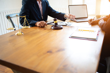 Judge Explaining To Businesswoman At Desk In Courtroom