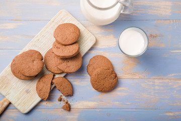 Pile of Delicious Chocolate Chip Cookies on a  board with Milk Bottles