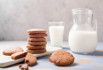 Pile of Delicious Chocolate Chip Cookies on a  board with Milk Bottles