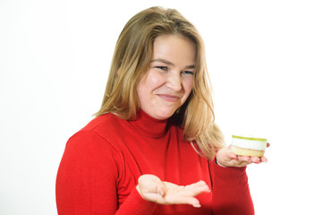 A fat girl on a white background is not happy with junk food. Studio shot.