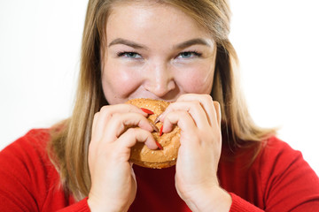 Young fat girl on a white background eats a burger. Studio shot