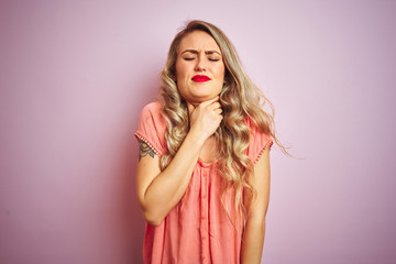 Young beautiful woman wearing t-shirt standing over pink isolated background Touching painful neck, sore throat for flu, clod and infection