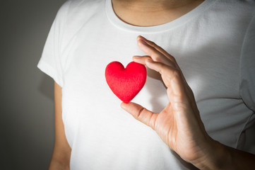 Red heart in girl hand.