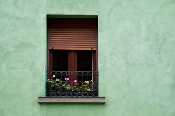 window on the green facade of the house in Bilbao city Spain