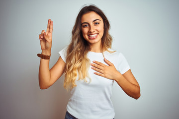 Young beautiful woman wearing casual white t-shirt over isolated background smiling swearing with...