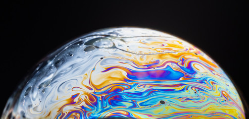 close up of a soap bubble looking like a planet in space.