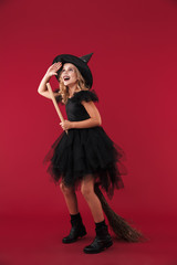 Pleased little girl witch in carnival halloween costume