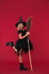 Pleased little girl witch in carnival halloween costume