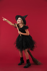 Pleased little girl witch in carnival halloween costume