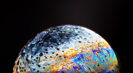 close up of a soap bubble looking like a planet in space.