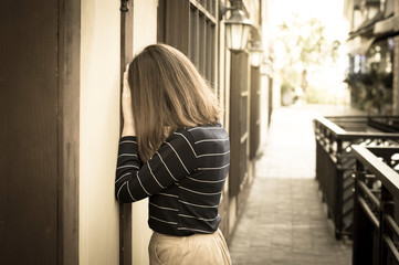 Sad woman crying at wall.
