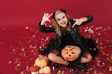 Obraz na płótnie Canvas Girl in carnival halloween costume showing photo frame gesture.