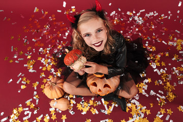 Obraz na płótnie Canvas Emotional optimistic little girl devil in carnival costume