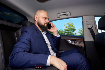 Successful young man talking on the phone in a car.
