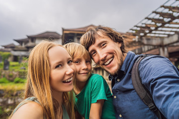 Naklejka premium Happy family of tourists in abandoned and mysterious hotel in Bedugul. Indonesia, Bali Island