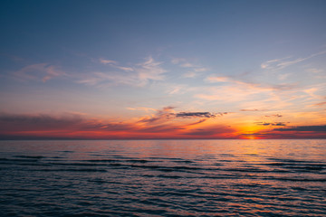 Evening by the sea, beautiful sunset over Baltic seashore, close up view on small waves