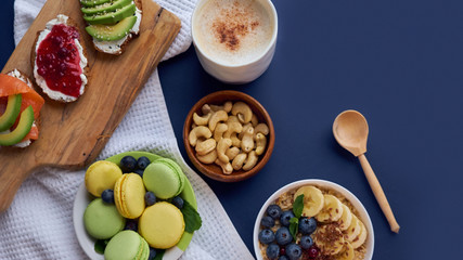 breakfast top view black background. oatmeal with berries, toasts on a wooden tray, nuts, coffee