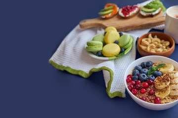 breakfast top view black background. oatmeal with berries, toasts on a wooden tray, nuts, coffee