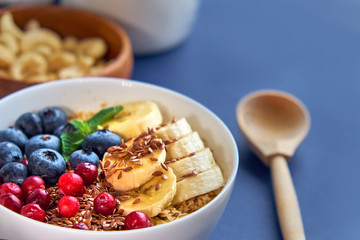 breakfast top view black background. oatmeal with berries, toasts on a wooden tray, nuts, coffee