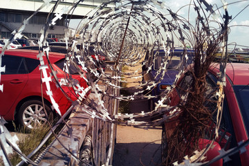 Barbed wire separates two city parking lots