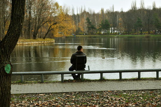 young man resting by the lake