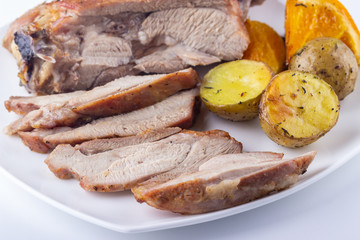 Baked turkey thigh with oranges and potatoes closeup