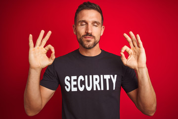 Young safeguard man wearing security uniform over red isolated background relax and smiling with eyes closed doing meditation gesture with fingers. Yoga concept.