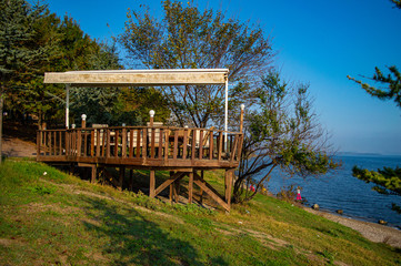 wooden porch facing a lake on a sunny day