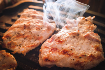 Roasting Fuming Chicken or Turkey Meat Fillets Seasoned with Spices on Electric Grill Plate.