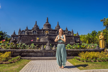 Young woman tourist in budhist temple Brahma Vihara Arama Banjar Bali, Indonesia