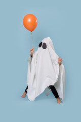 Little kid dressed as white ghost on halloween making funny stance