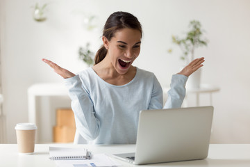 Surprised young mixed race businesswoman received email with good news.