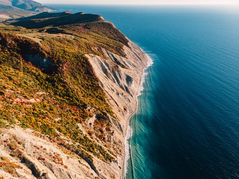 Aerial view of rocky cliff, coastline and sea with wave in Anapa